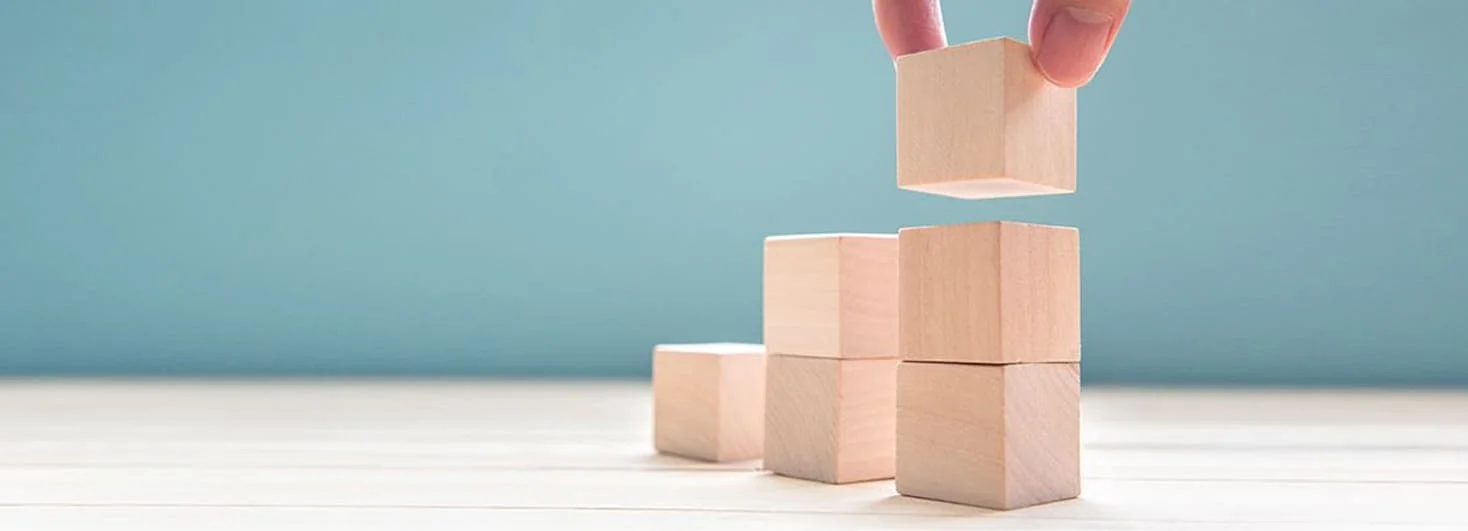 Stacked wooden blocks representing thoughtful growth
